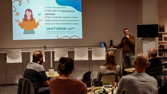 personen die zittend luisterend naar spreker thema avond