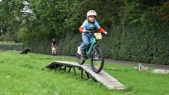 Meisje op een hindernis van het bikeparcours