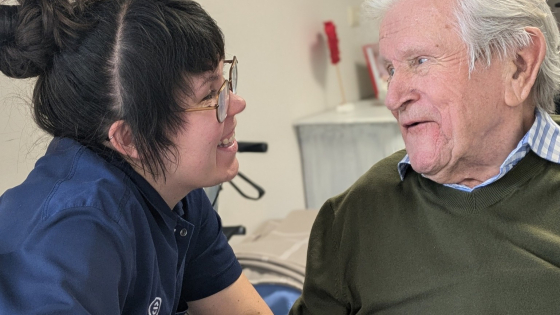 Een personeelslid van Biezenheem in gesprek met een bewoner. Ze lachen allebei, het is een fijn gesprek