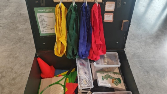 Koffer 'De Saboteur' met daarin onder andere blinddoeken, een racket, een kegel, ...