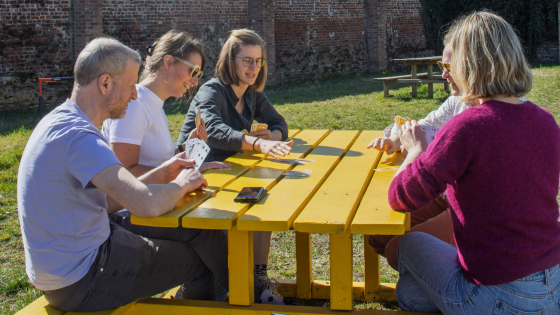 Gele picknickbank met mensen aan