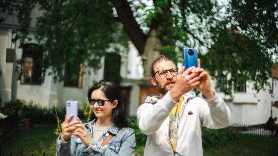 Man en vrouw staan met hun telefoon in de lucht foto's te nemen