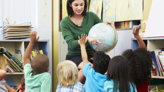 Leerkracht geeft les aan jonge kinderen.