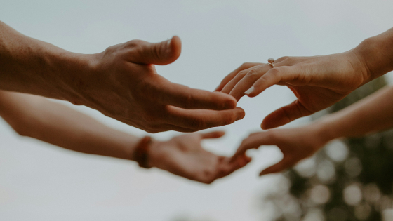 twee paar handen die elkaar vasthouden