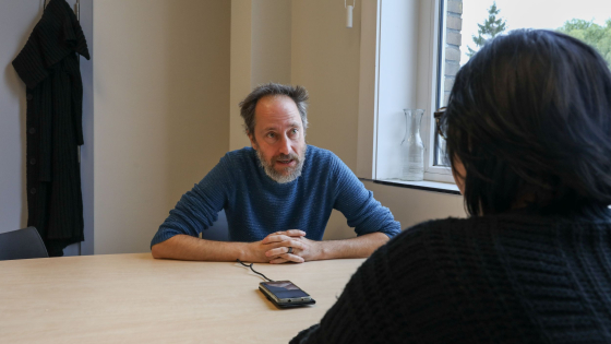 man in een bureau met een gsm voor zich