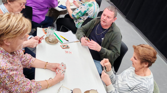 Een groepje van vier leden van NEOS zijn aan het kaarten aan tafel