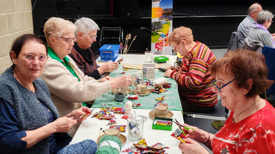5 dames aan tafel, ze maken een vlaggenlijn