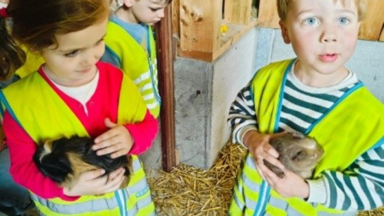 2 kleuters houden elk een cavia vast