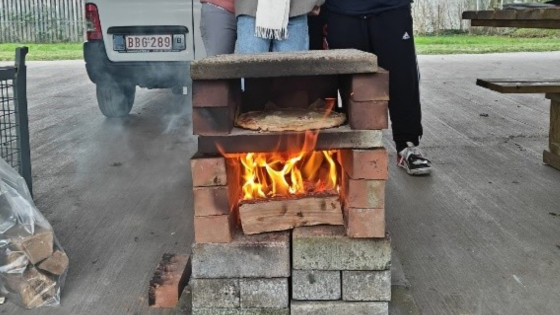 4 mensen bij een pizzaoven