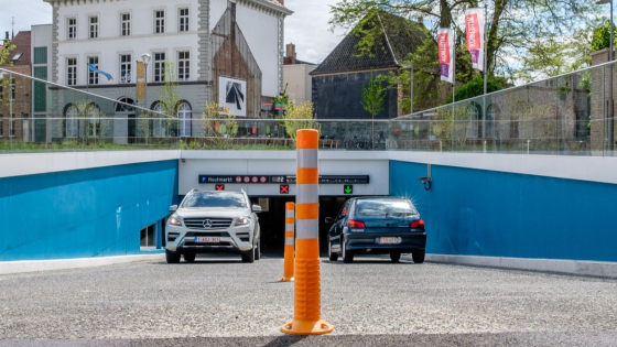 Inrit van parking Houtmarkt. Een wagen rijdt uit, terwijl een andere net inrijdt