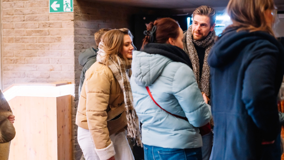 aanwezigen lezing digitaal jaaroverzicht die wachten om de zaal binnen te gaan