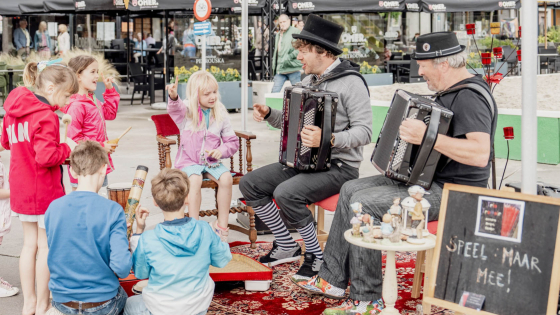 kindjes luisteren naar 2 accordeonisten 