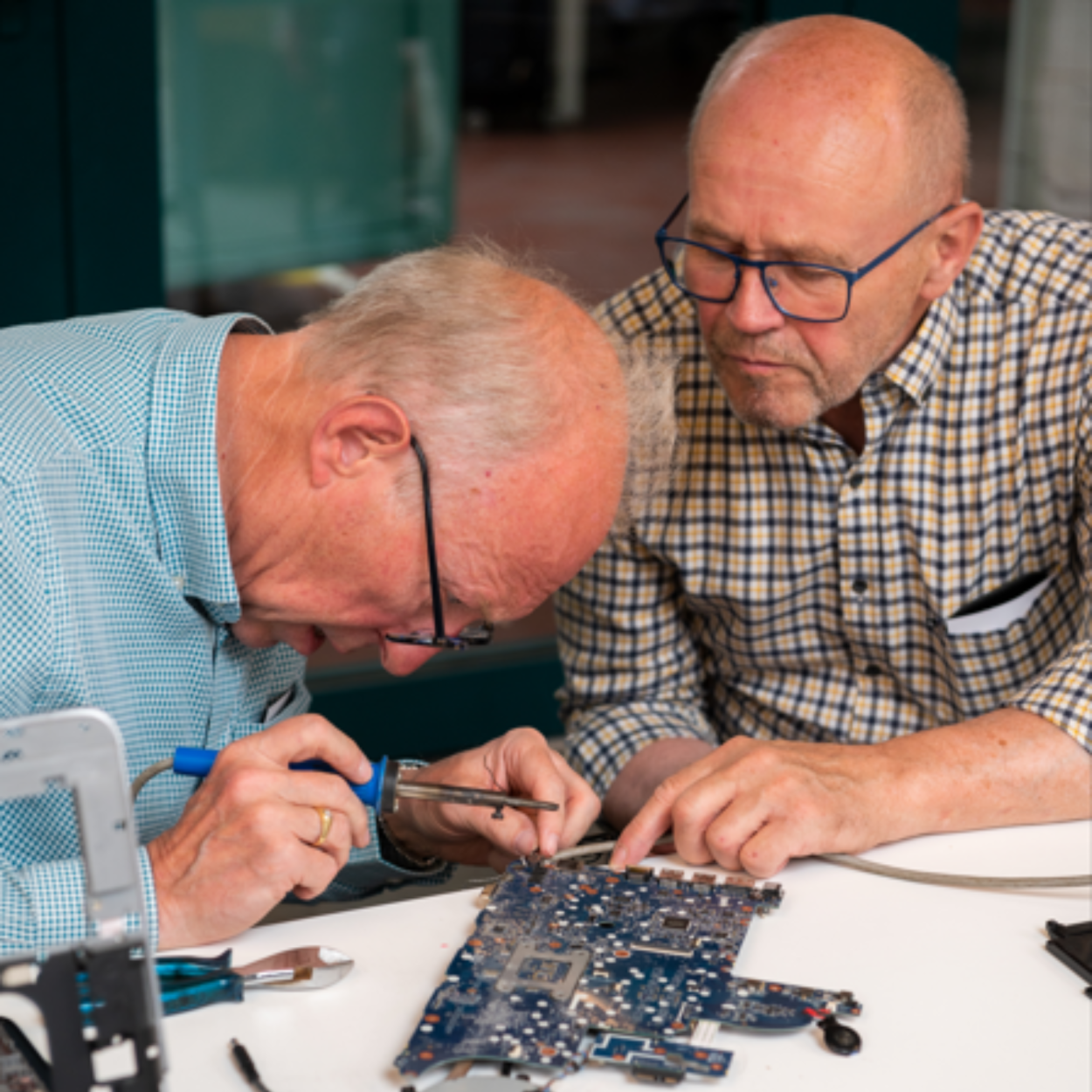 twee vrijwilligers herstellen computer 