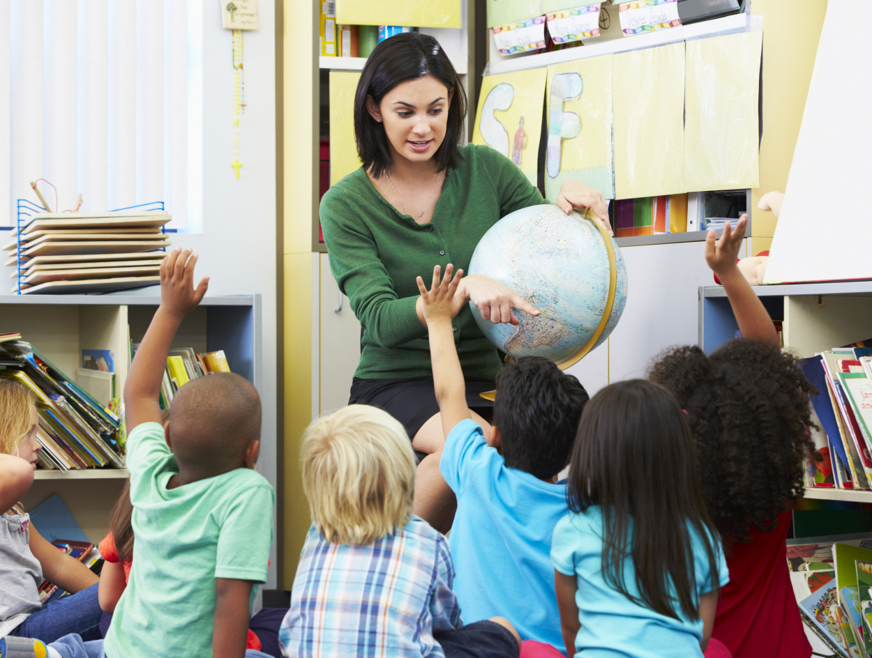 Leerkracht geeft les aan jonge kinderen.