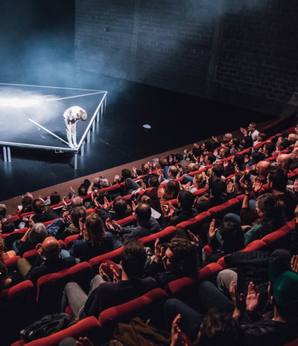 Volle zaal die naar een podium kijkt