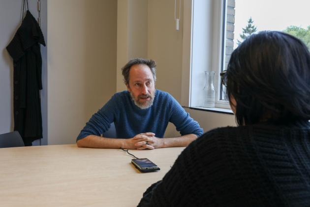 man in een bureau met een gsm voor zich