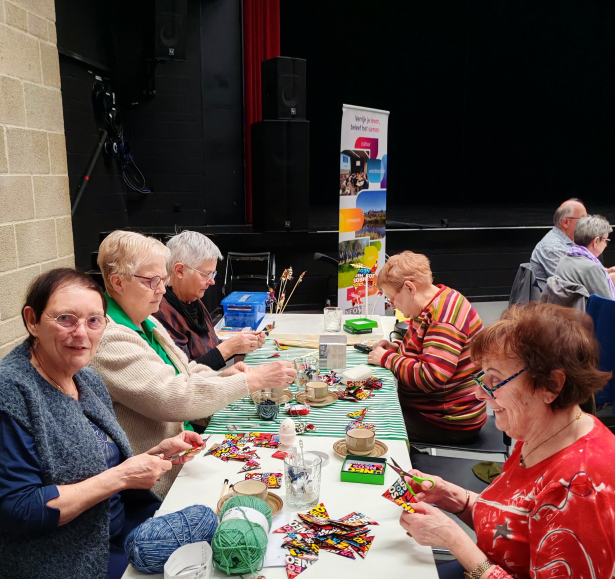 5 dames aan tafel, ze maken een vlaggenlijn
