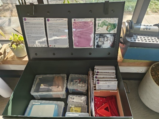 open koffer met opdrachten en doosjes