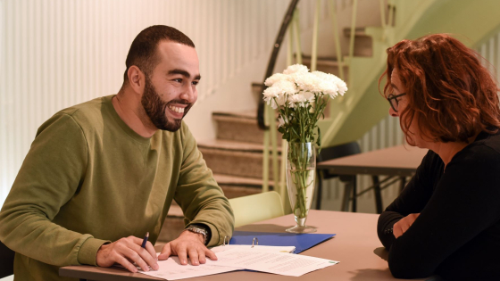 een maatschappelijk werker in gesprek met een vrouw